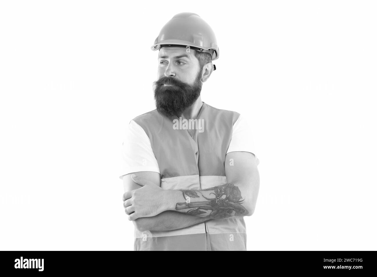 wondered bearded supervisor man in orange vest. studio shot of supervisor man wearing helmet. Stock Photo