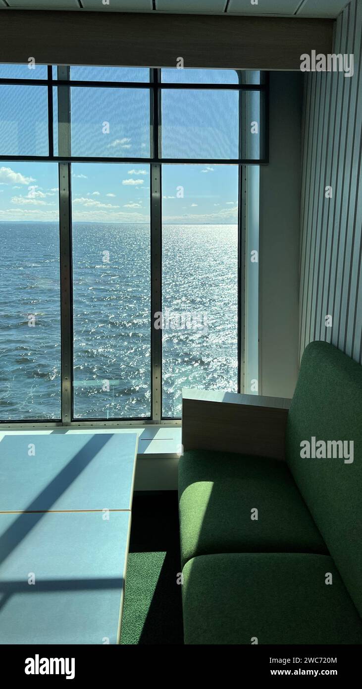 green sofa against the background of panoramic windows in sunny weather. Interior design Stock Photo