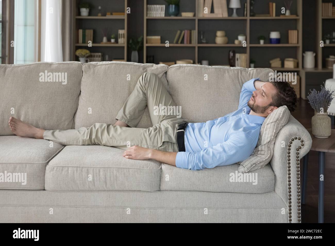 Side view man enjoy daytime nap on comfy sofa Stock Photo