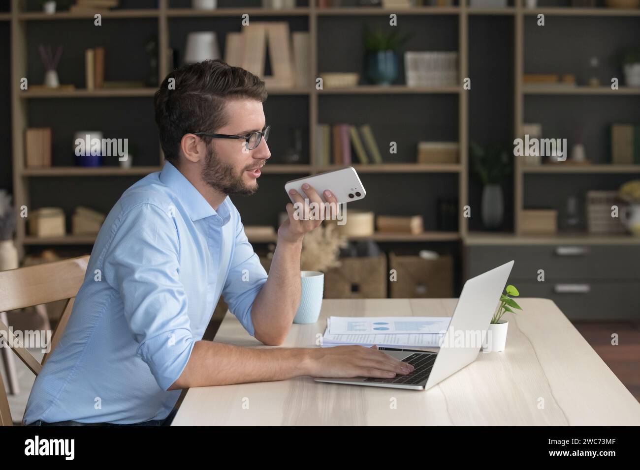 Businessman holding smartphone talk to client using speakerphone Stock Photo