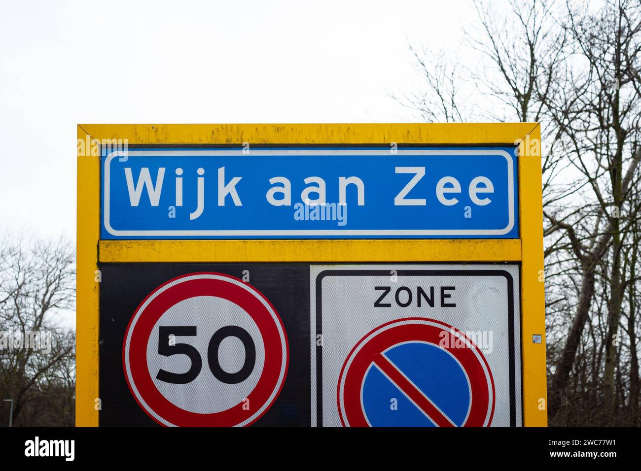 Place name sign of the coastal village of Wijk aan Zee, The Netherlands. Below are signs of a speed limit of 50 and a no parking sign. Stock Photo