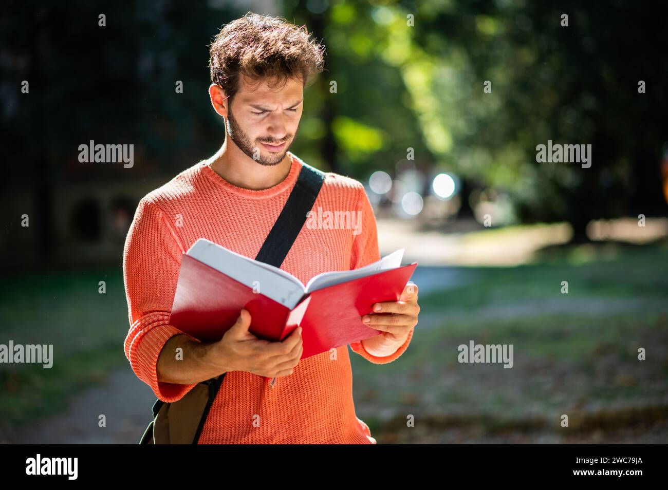 Student reading a book outdoor in a college courtyard Stock Photo