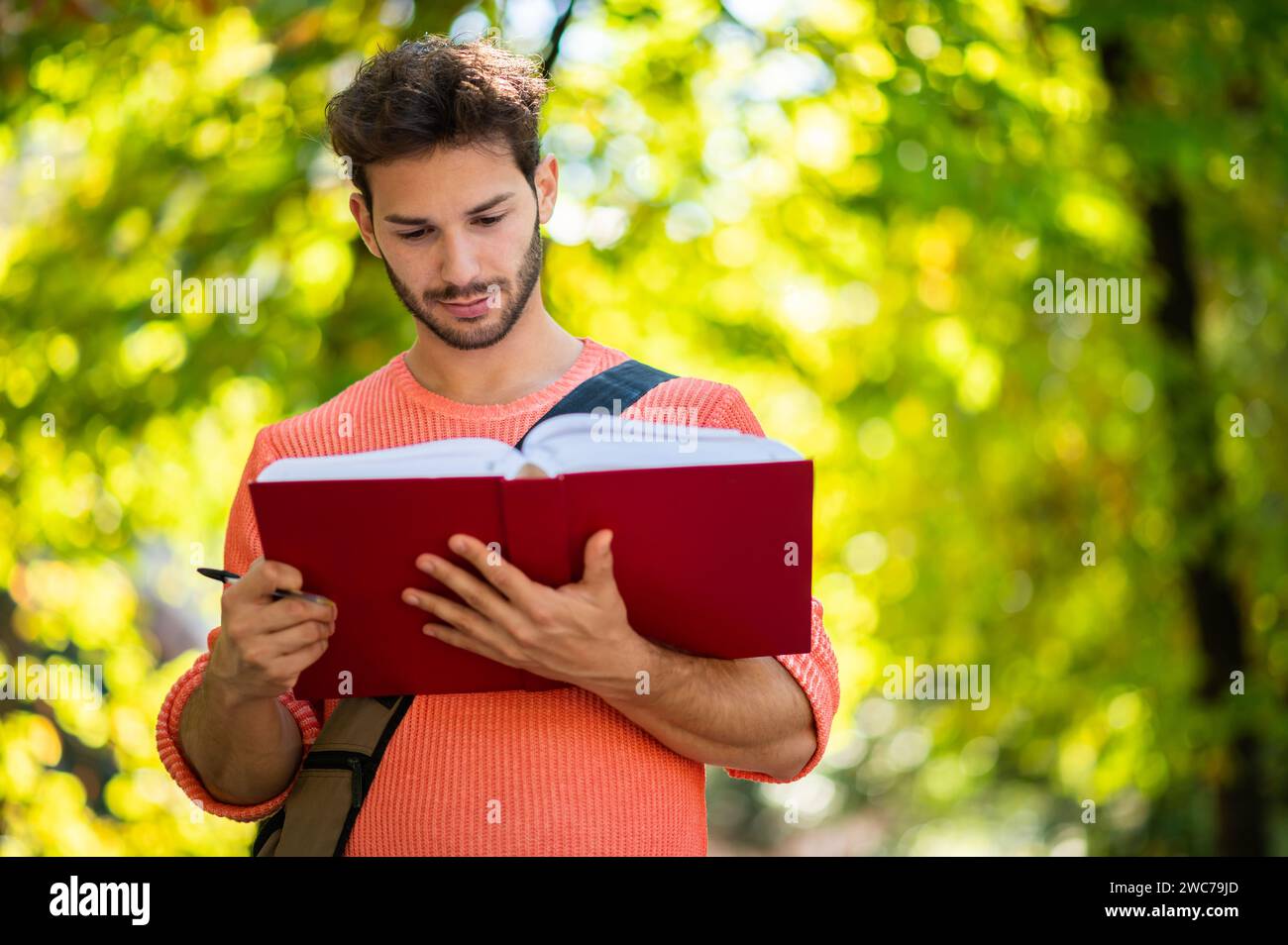 Young male student reading a book outdoor Stock Photo