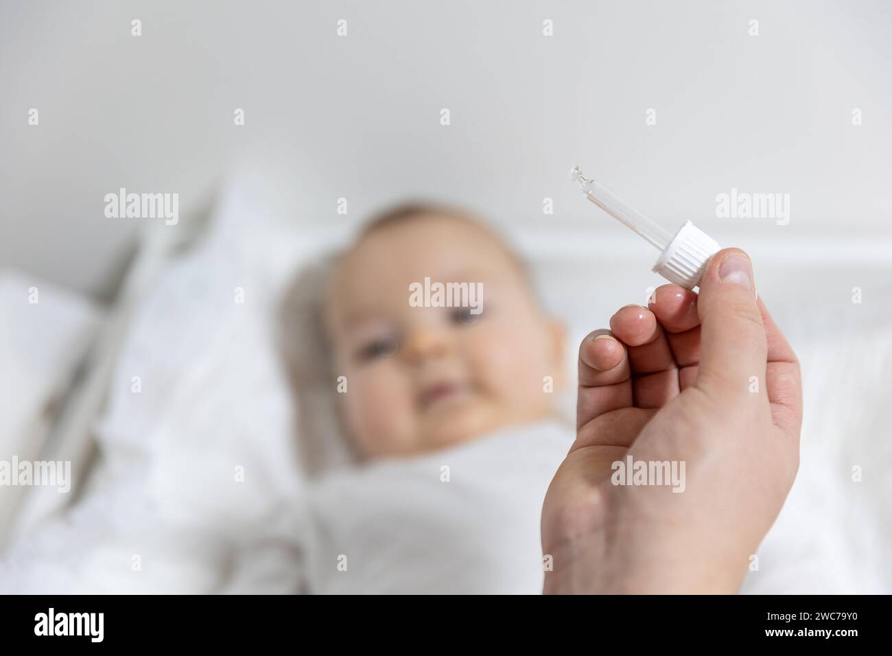 Mom giving vitamin D3 to newborn baby for care of the proper