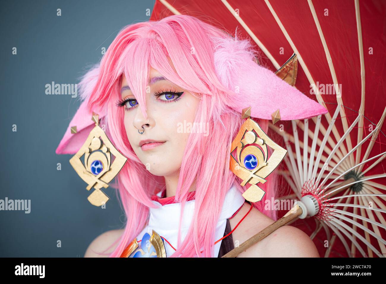 a-female-cosplayer-in-a-pink-anime-costume-wearing-pink-hair-stock