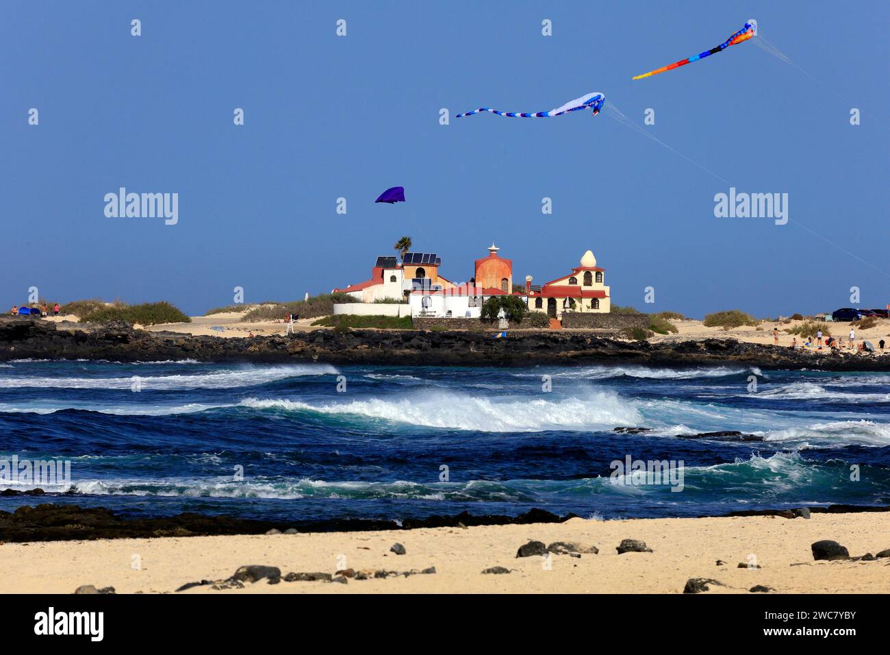 Colourful, large kites at La Concha beach, and the Dream House designed by architect and artist Antonio Padrón Barrera . Taken November 2023 Stock Photo