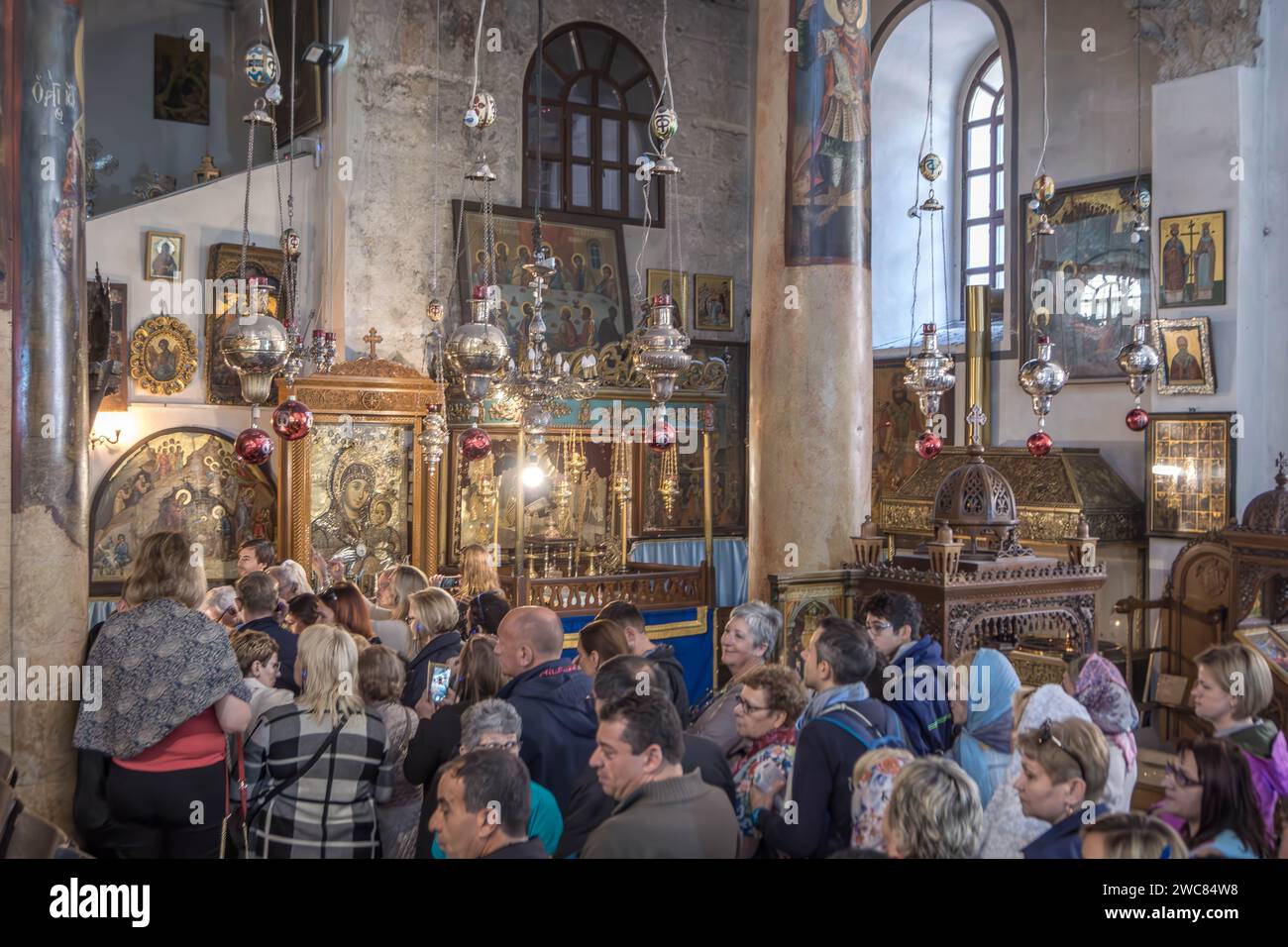 The religious people in front of Christian icons in the Church of the
