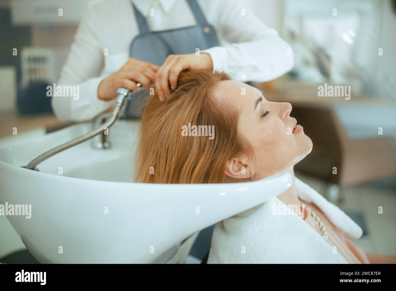 40 years old hair salon employee in modern hair studio with relaxed