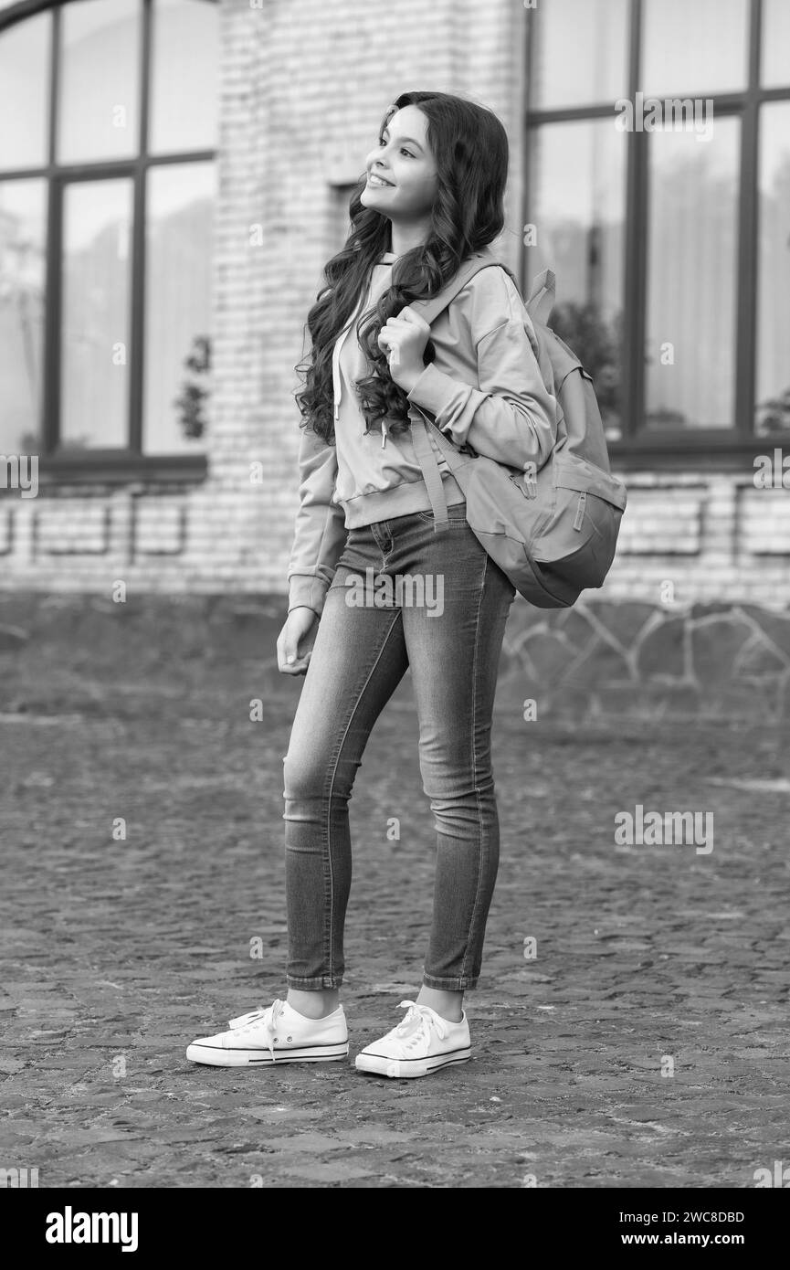 photo of cute school girl in september with backpack. school girl in september outdoor. Stock Photo