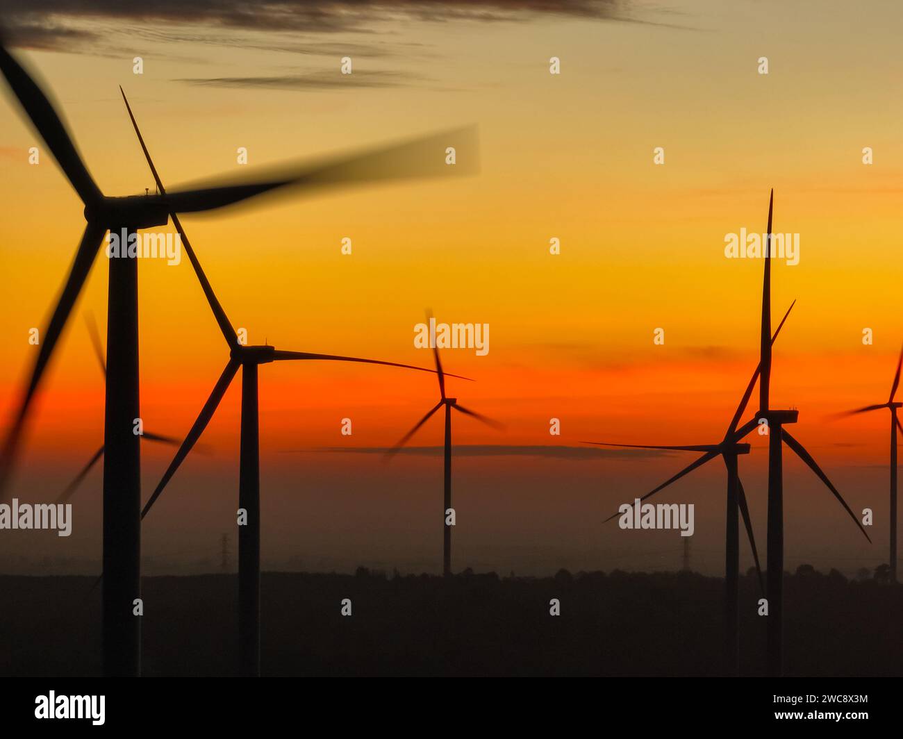Wind farm landscape against sunset sky. Wind energy. Wind power. Sustainable and renewable energy. Wind turbines generate electricity. Green tech Stock Photo