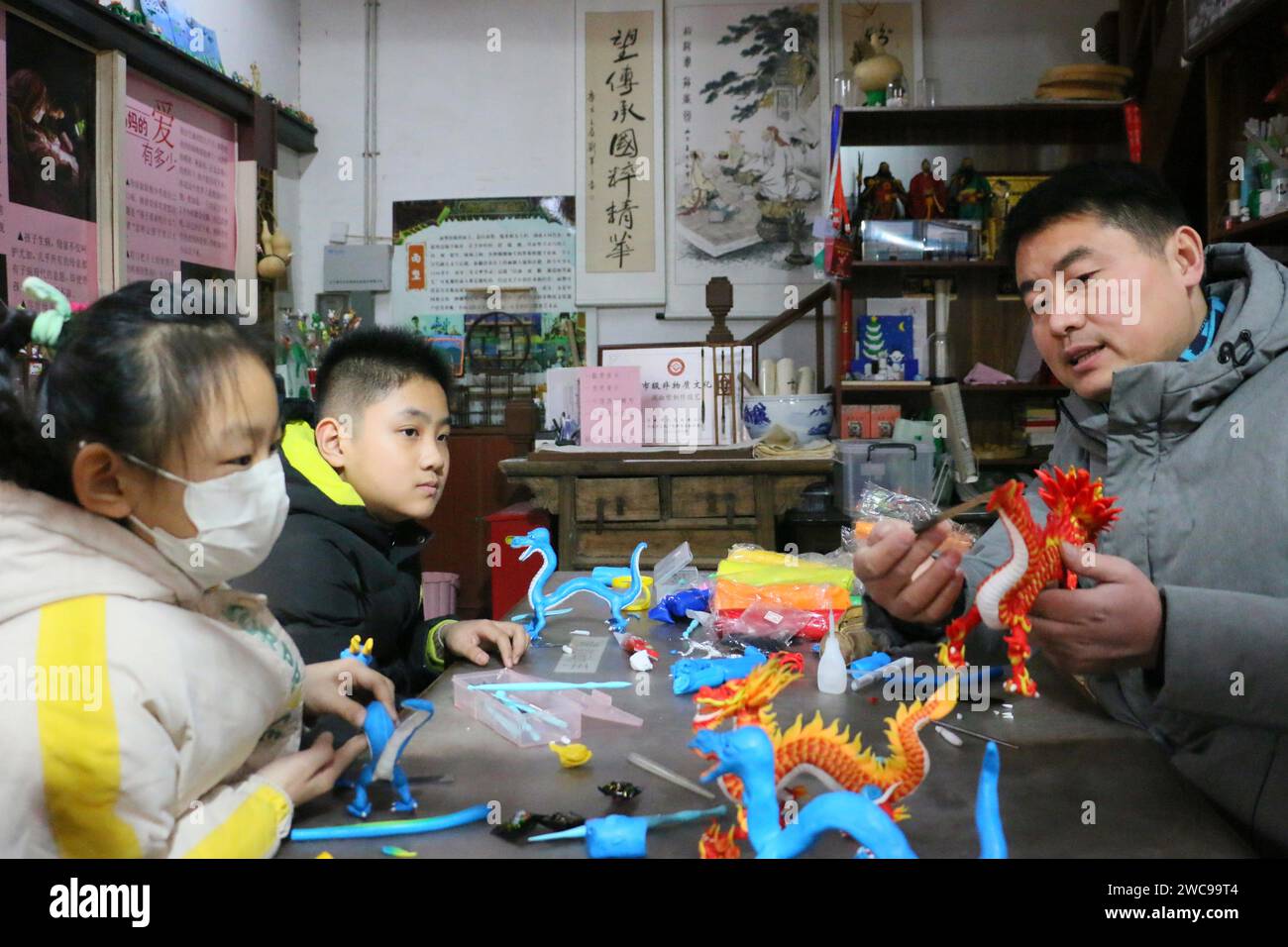 ZOUCHENG, CHINA - JANUARY 14, 2024 - Folk dough figurine artist Sun Yandou guides children to make dough figurine dragon series in Zoucheng city, Shan Stock Photo