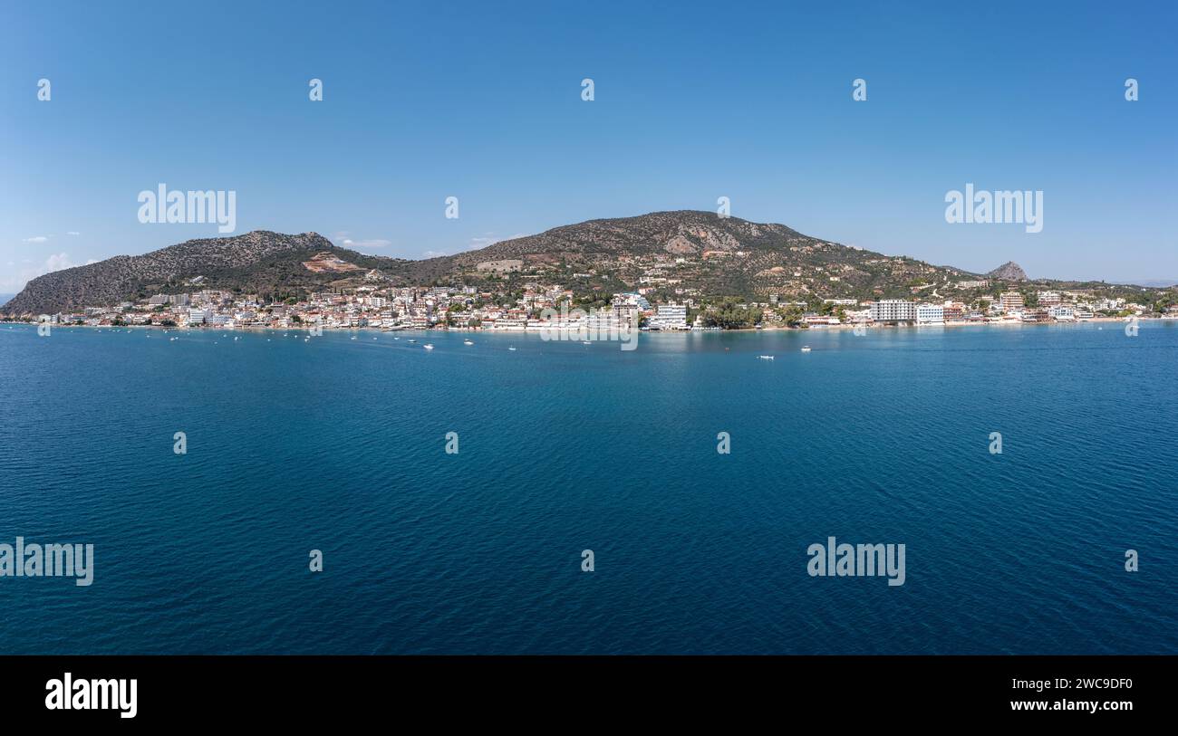 Tolo in Asini, Argorida, Peloponnese, Greece. Aerial drone panoramic view of village, moored boat in ripple sea water, blue sky background. Space Stock Photo