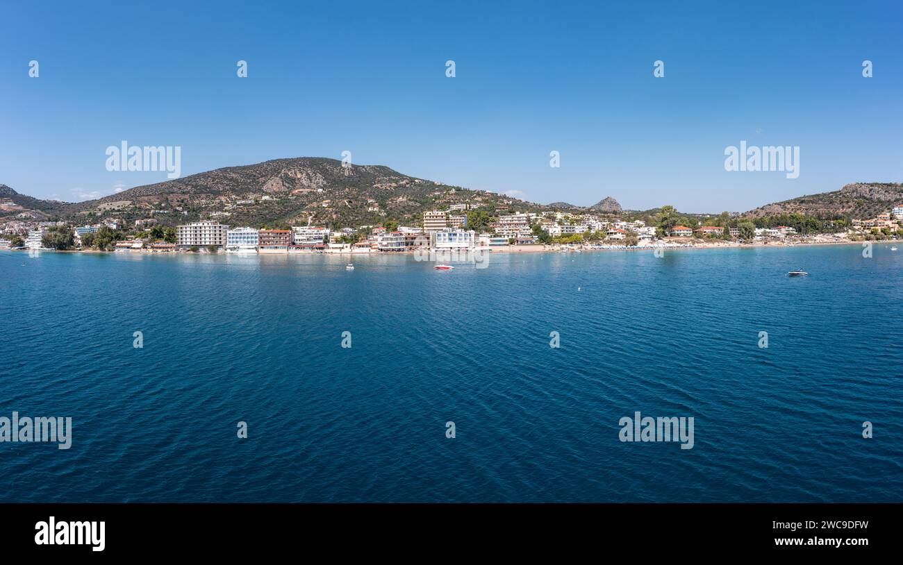 Tolo near Nafplio, Argorida, Peloponnese, Greece. Aerial drone panoramic view of village, moored boat in ripple sea water, blue sky background. Space Stock Photo