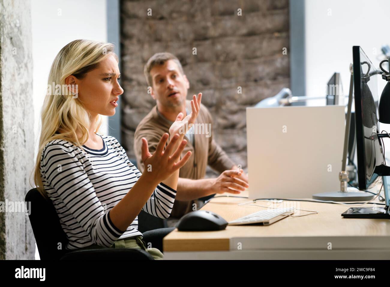 Portrait of a disappointed woman programmer looking stressed out while working on a computer code Stock Photo