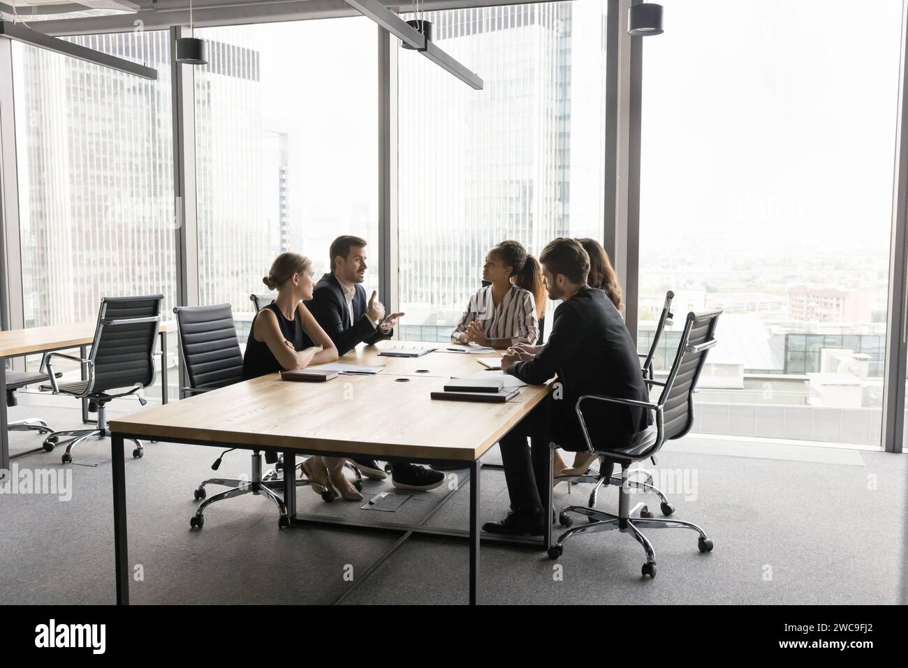 Multiethnic business team working on project, talking at table Stock Photo