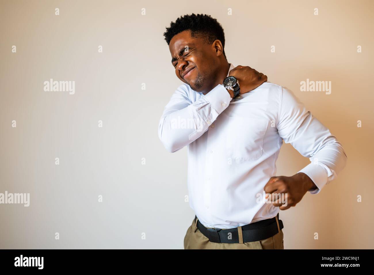 Portrait of young businessman who is having pain in his back. Copy space on image for your text or advert. Stock Photo