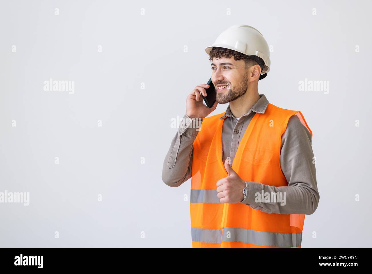 Engineering, man and phone call for communication, construction update or planning on studio mockup. Builder or worker talking on mobile or architectu Stock Photo