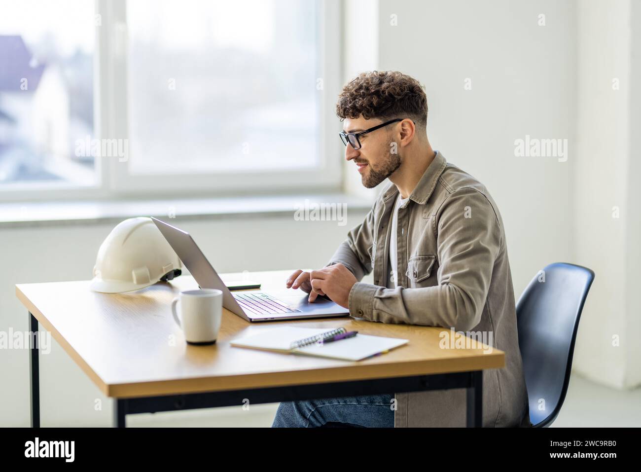 Young business man working at home with laptop and papers on desk Stock Photo