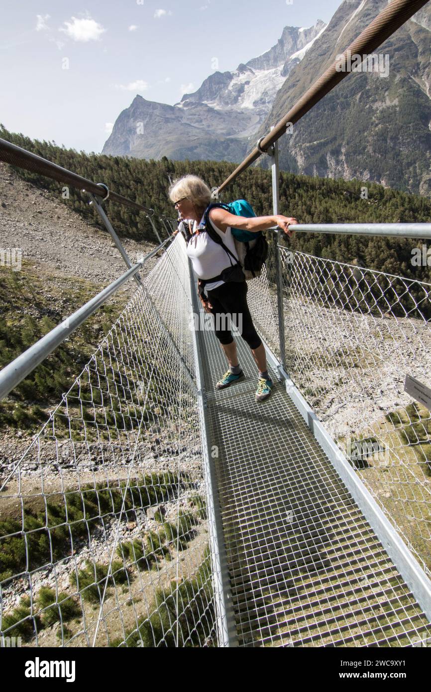 Hiker on Charles Kuonen Suspension Bridge, Valais, Switzerland Stock Photo