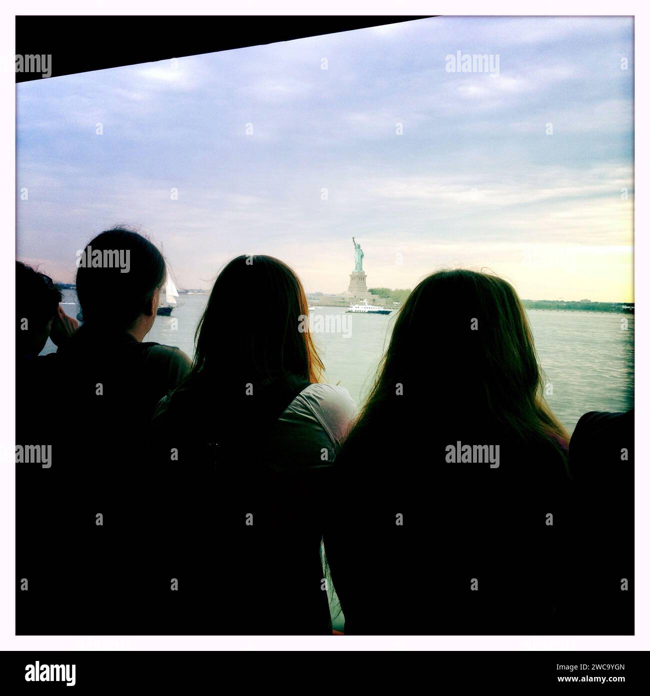 Passengers on Staten Island Ferry with Statue of Libery in Background Stock Photo