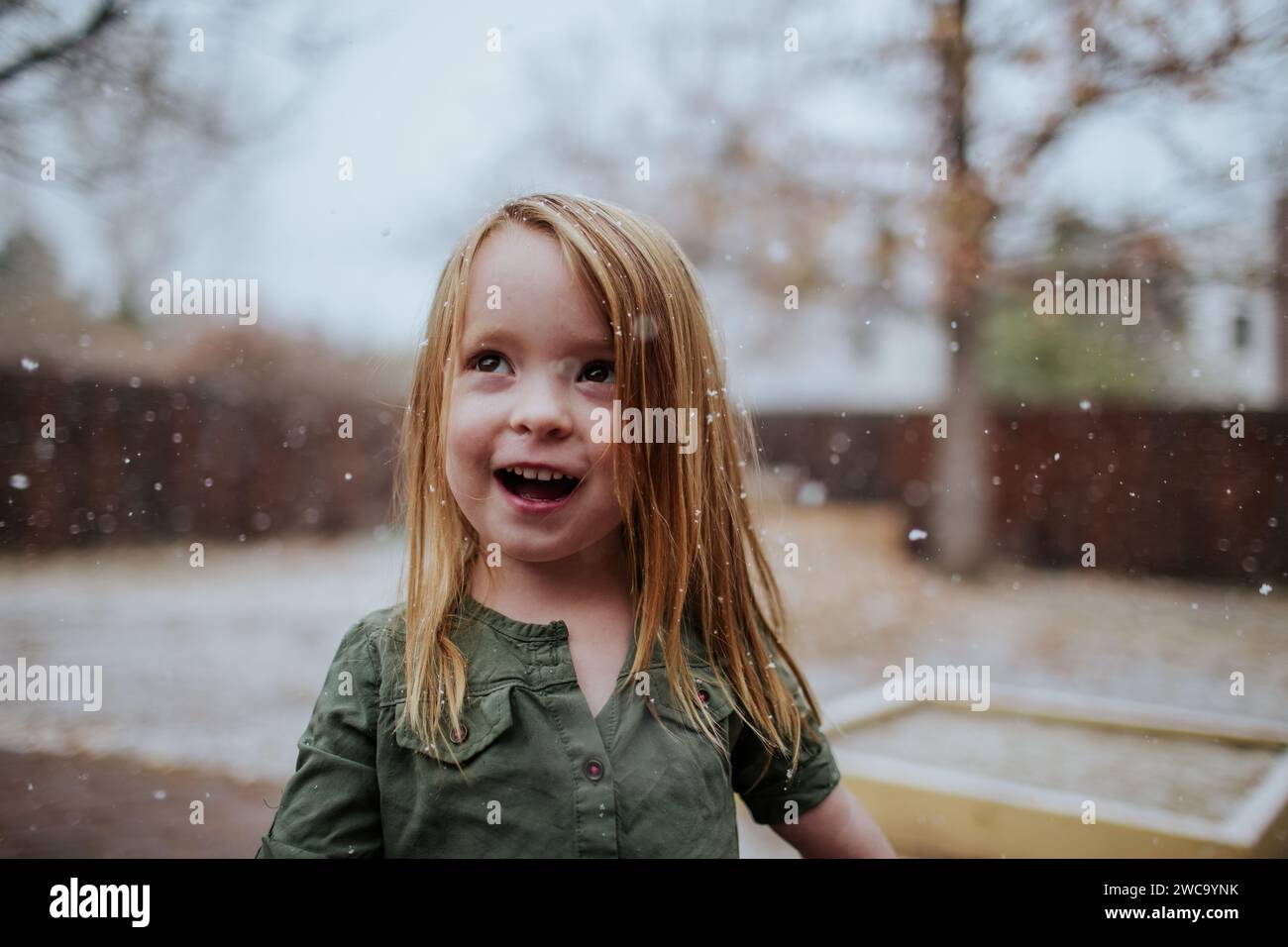 Smiling preschooler playing in snow outside Stock Photo