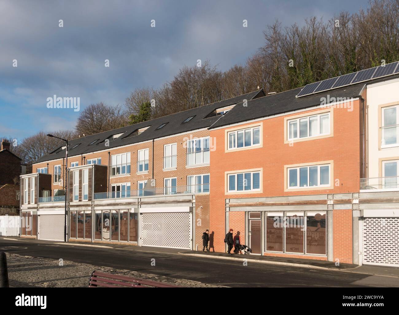 Couple walking past new waterfront apartments in Bell Street, North