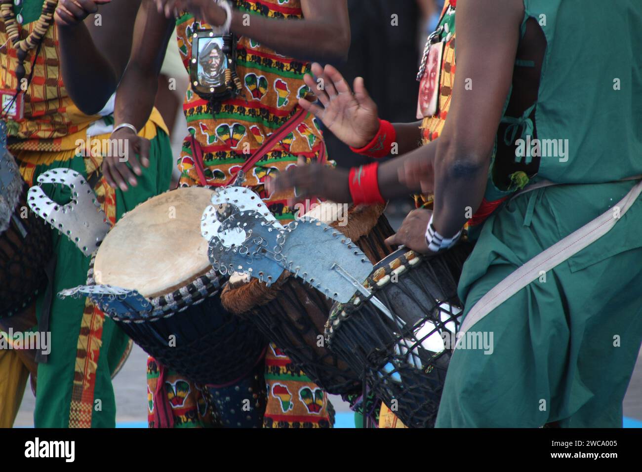 A group of folk drummers from Kenya perform in colorful attire in a spacious setting Stock Photo