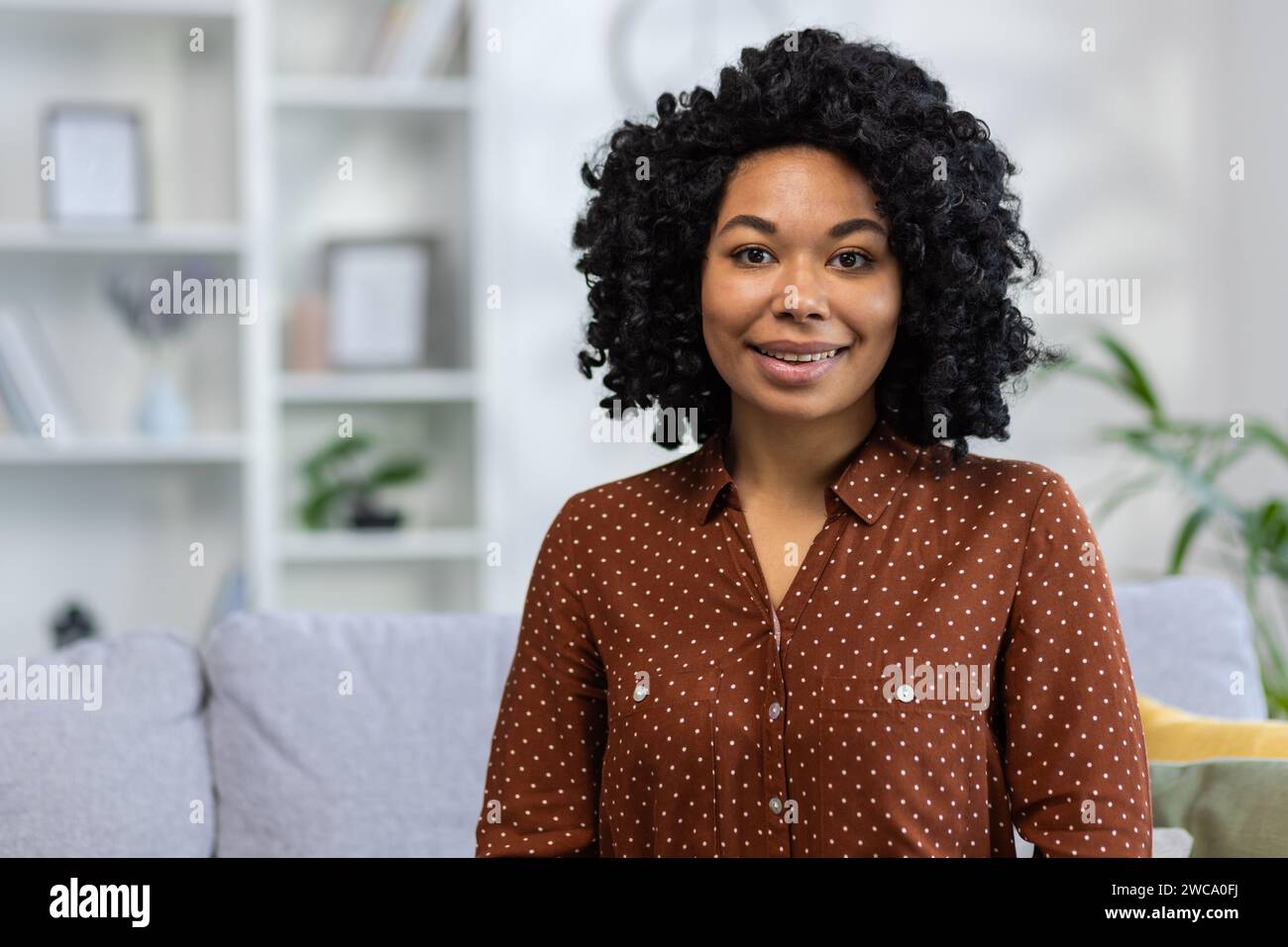 Portrait of a smiling young African American woman with curly hair ...