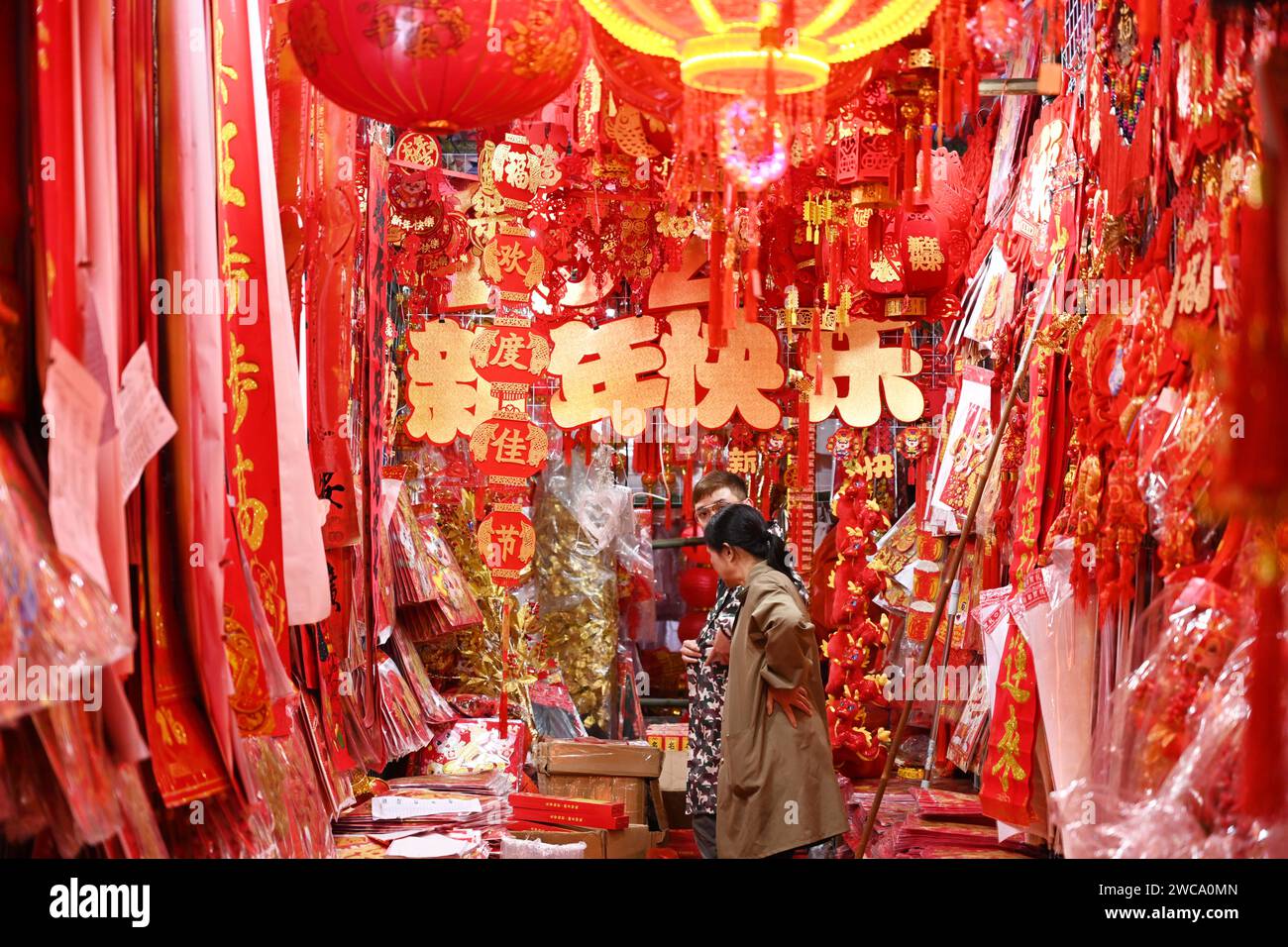 People are buying lanterns and other mascot ornaments with dragon elements at a traditional Chinese New Year shopping street in Nanning, China, on January 14, 2024. (Photo by Costfoto/NurPhoto) Stock Photo