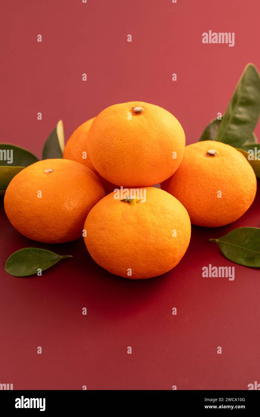Chinese lunar new year background with fresh tangerine, red envelope, paper fan and decorations for Spring Festival. Stock Photo
