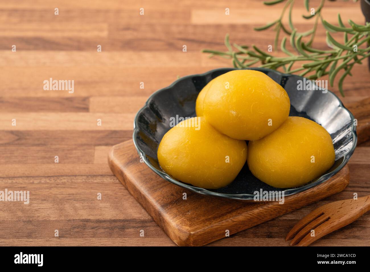 Homemade sweet potato yam bun with ground pork meat, mushroom and chopped bamboo shoot fillings inside in a bowl on wooden table background. Stock Photo