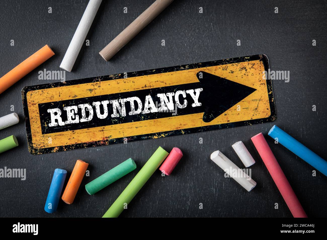 Redundancy. Direction arrow with text on a dark chalkboard background ...