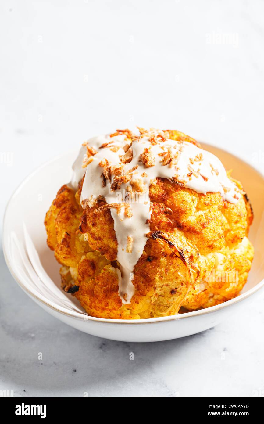 Whole roasted spicy cauliflower with tahini dressing and caramelized ...