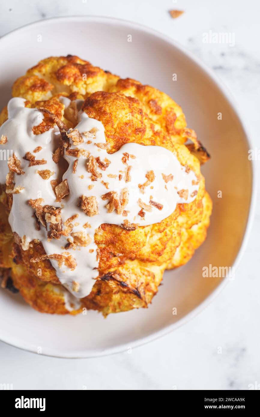 Whole roasted spicy cauliflower with tahini dressing and caramelized ...