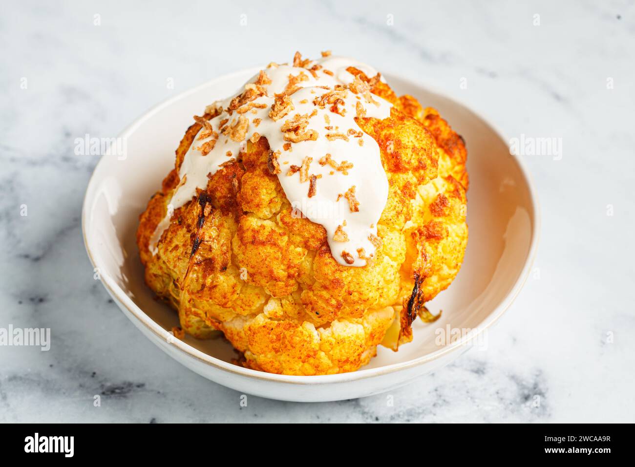 Whole roasted spicy cauliflower with tahini dressing and caramelized ...