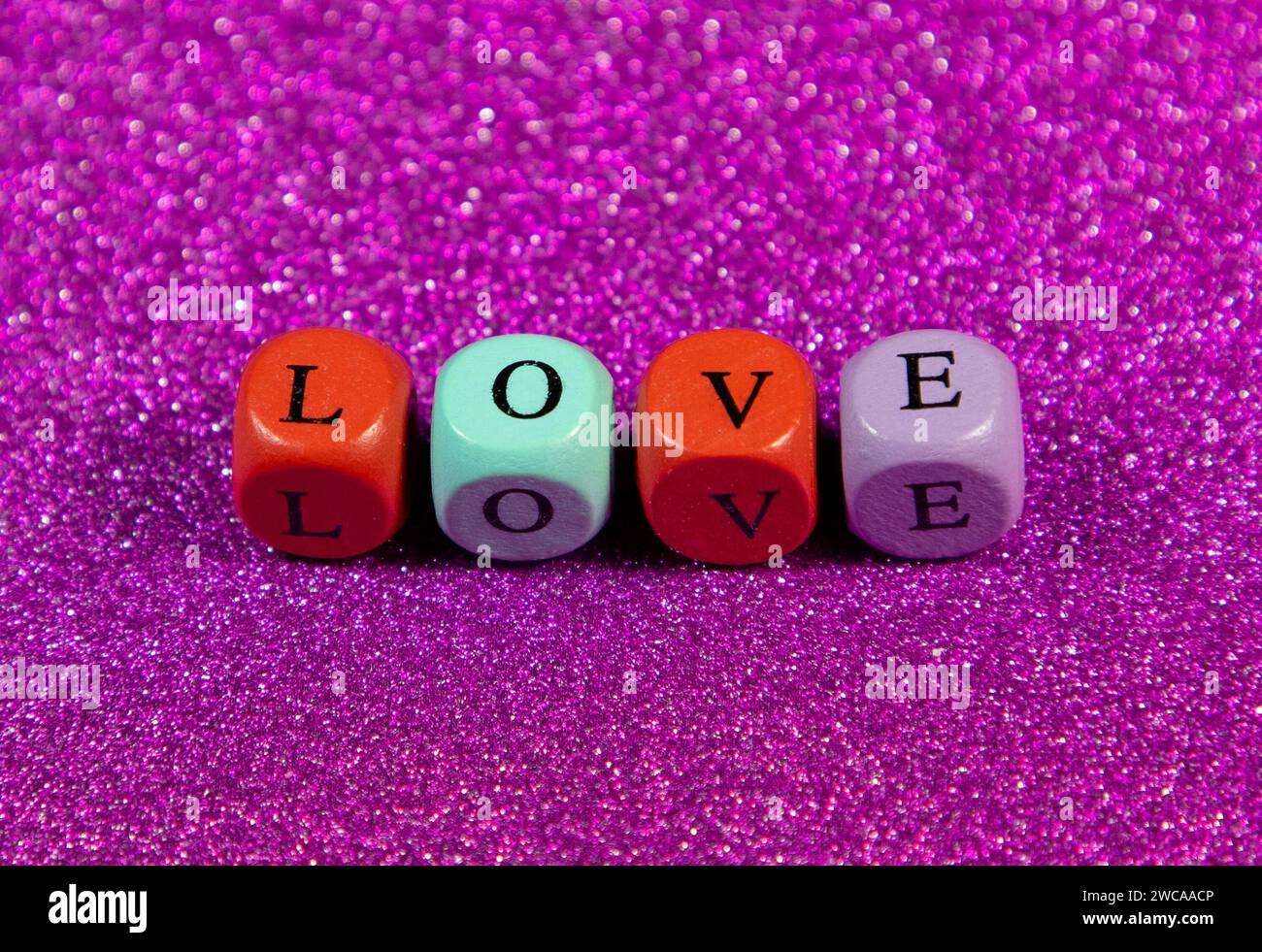 A purple background with the word 'Love' written with wooden cubic beads Stock Photo