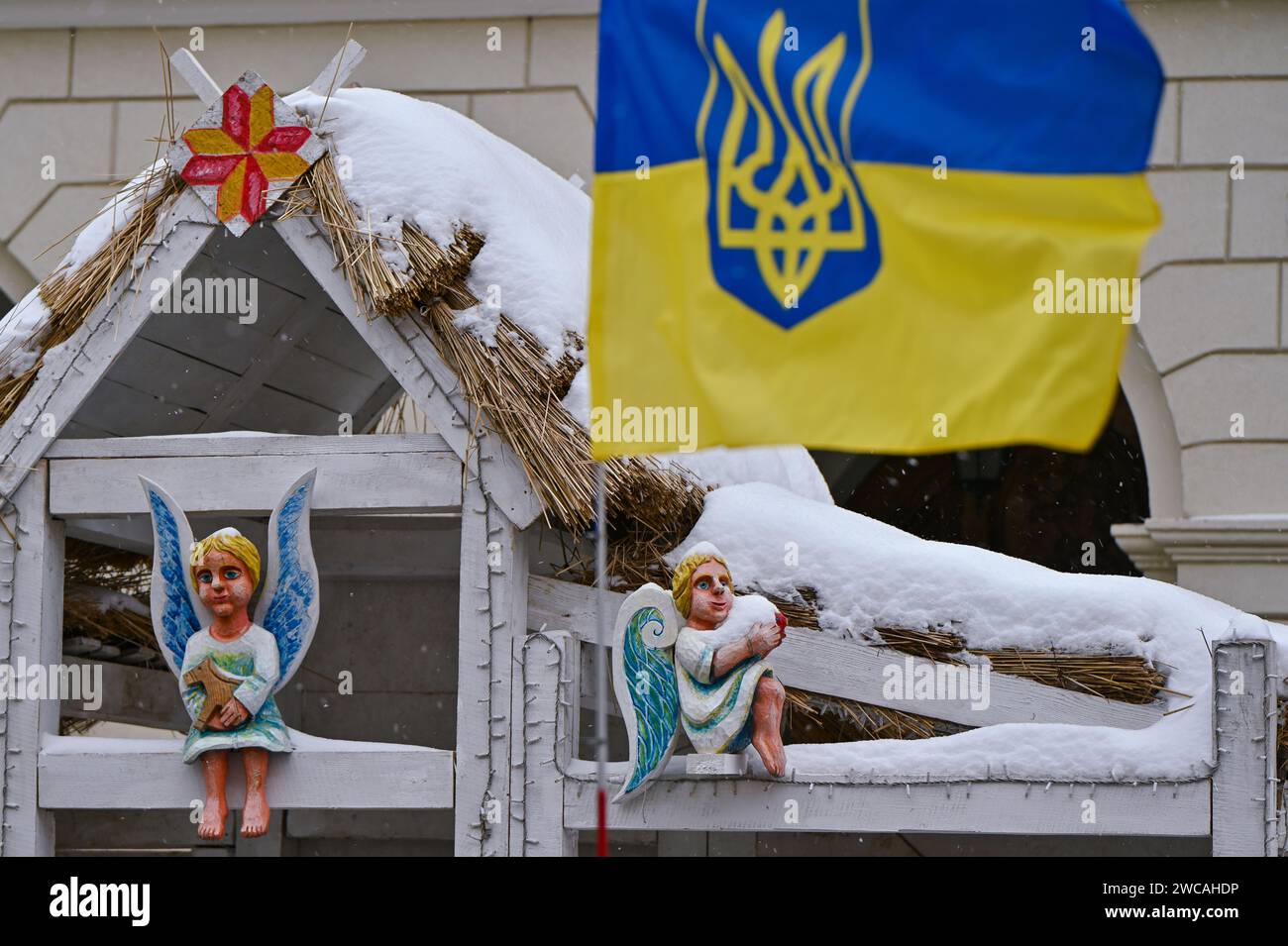 Non Exclusive: LVIV, UKRAINE - JANUARY 14, 2024 - The Ukrainian state flag and a nativity scene are seen outside the Lviv City Council, where the wive Stock Photo