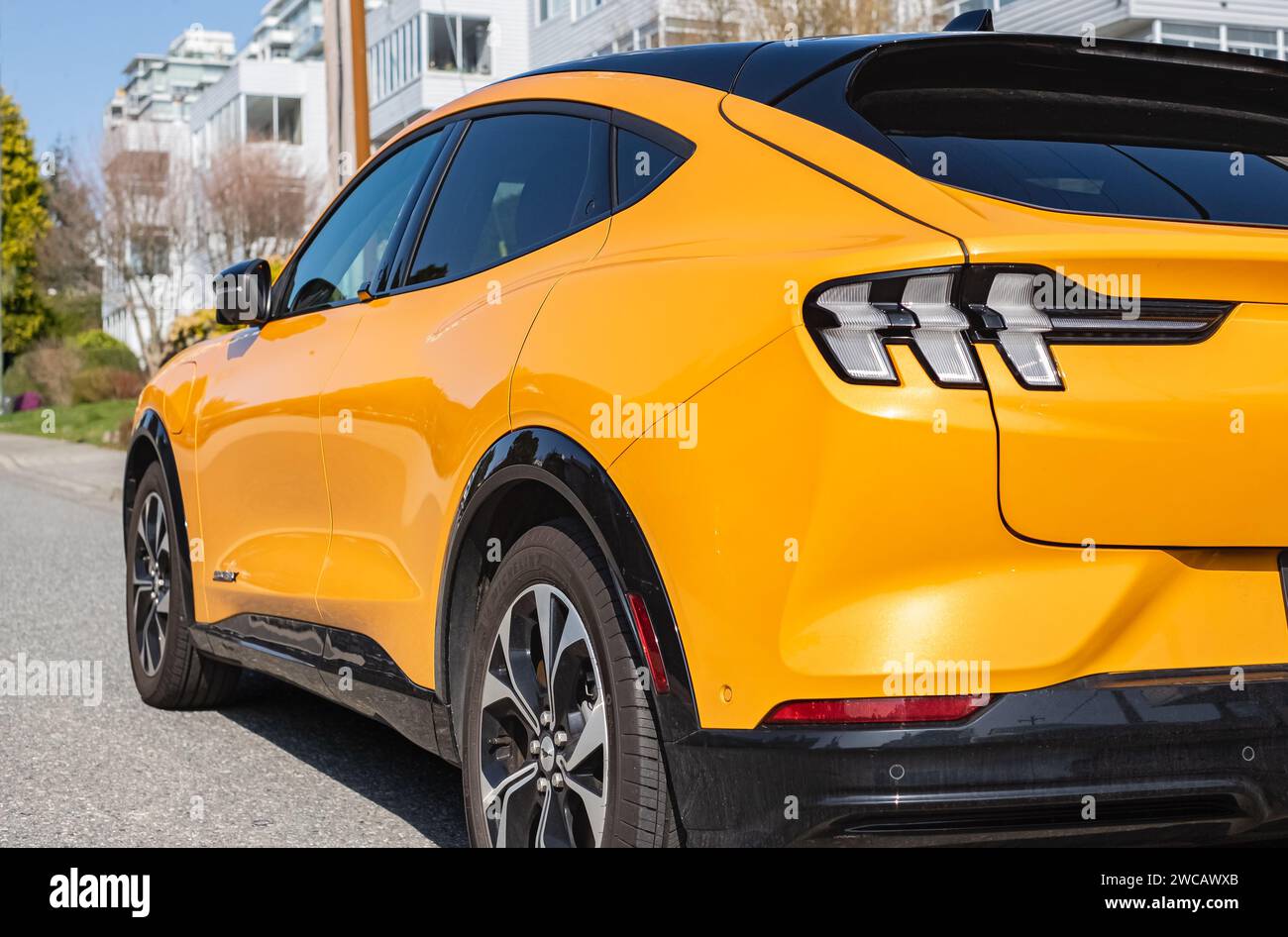 Yellow muscle car Ford Mustang. Headlights of yellow modern car. Back view. Ford Mustang GT parked on road side. Street photo, nobody-Vancouver Canada Stock Photo