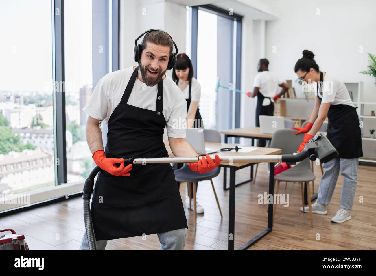 Happy team of people in black aprons cleaning modern office Stock Photo Alamy