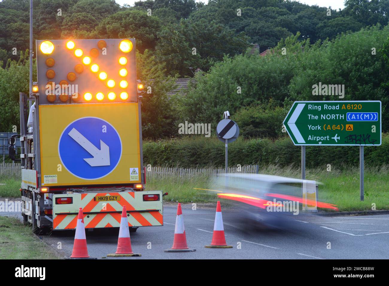 traffic passing flashing warning lights on highway maintenance lorry