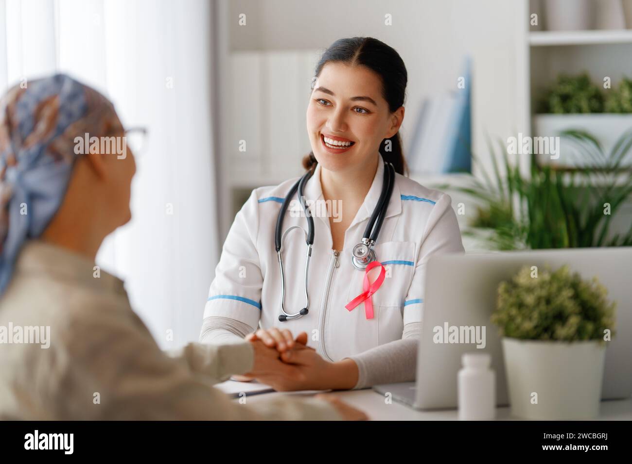 Colour ribbon for concept of illness awareness. Female patient listening to doctor in medical office. Raising knowledge on people living with disease. Stock Photo
