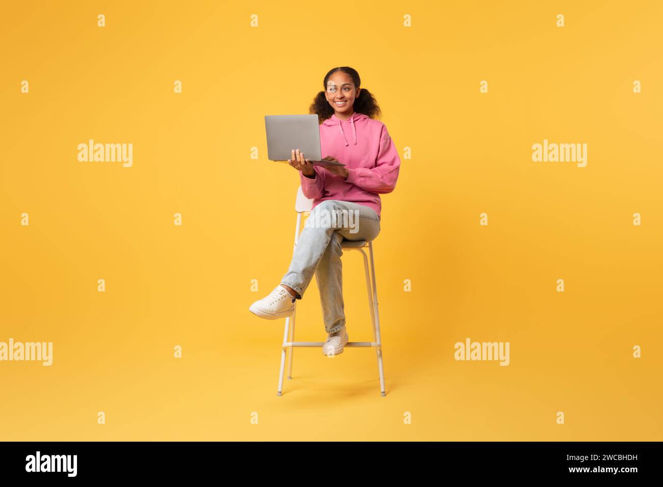 African American Teen Student Girl Using Laptop Over Yellow Background ...