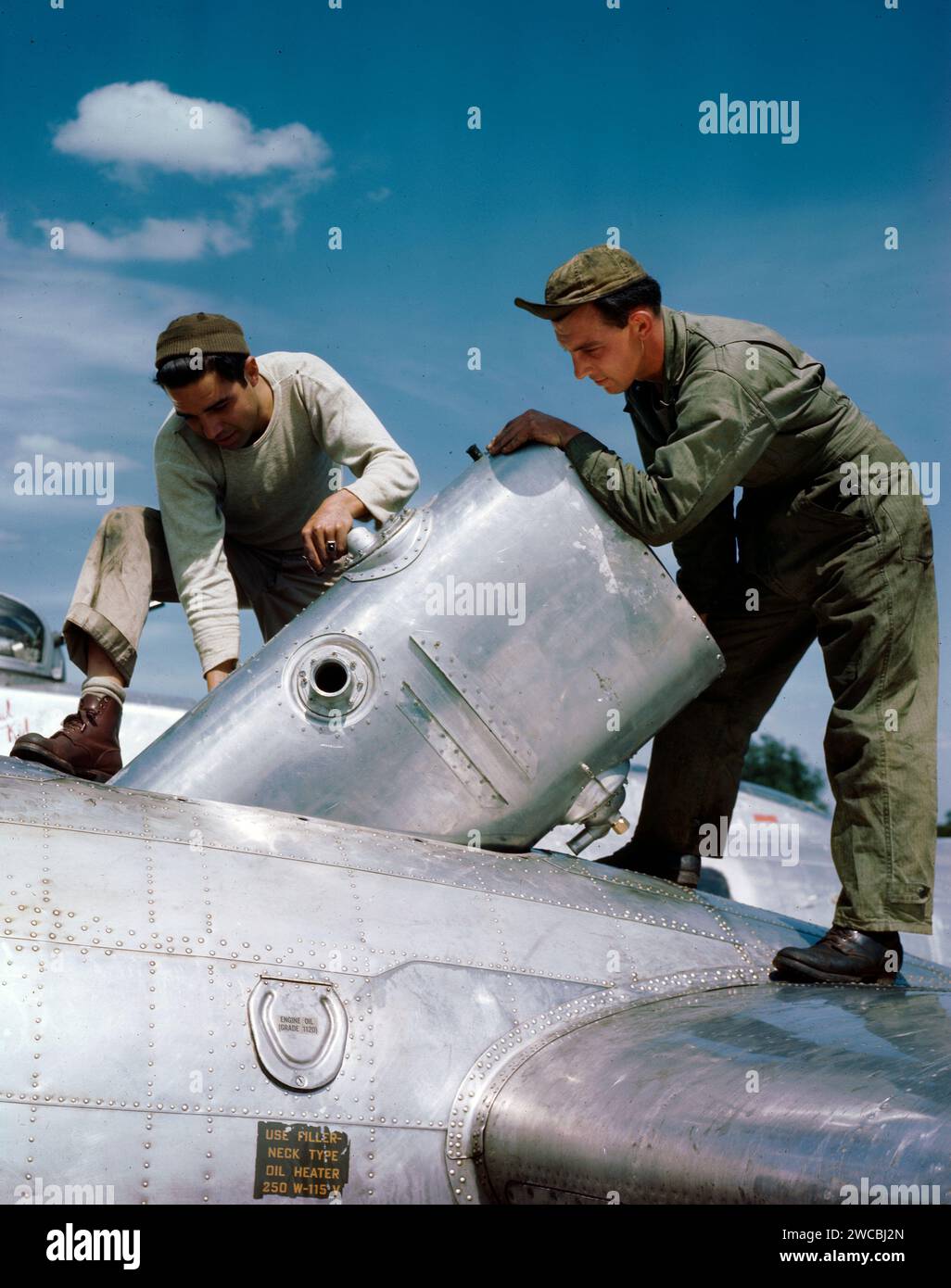 Replacing an oil tank in a flak damaged Boeing B-17 at a base in England during World War II Stock Photo