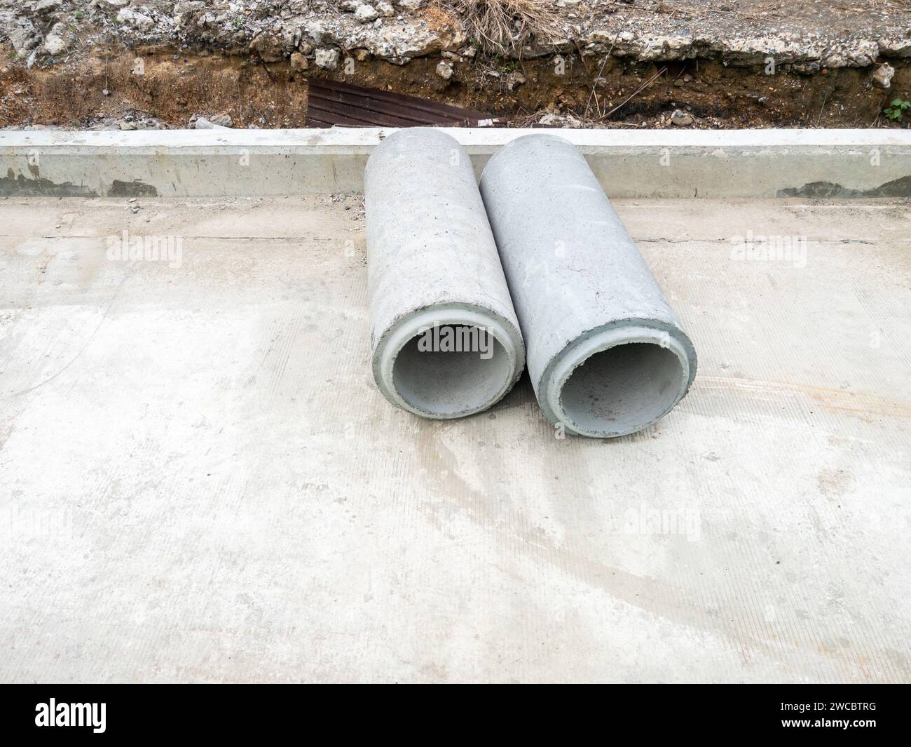 The new AC pipe (asbestos cement pipes) on the concrete road for use as