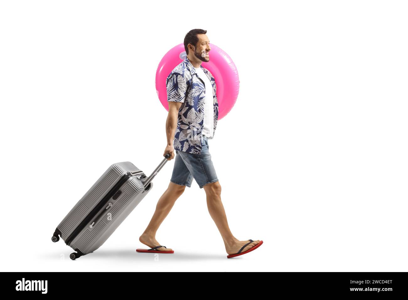 Man pulling a suitcase smiling and carrying a swimming ring isolated on white background Stock Photo