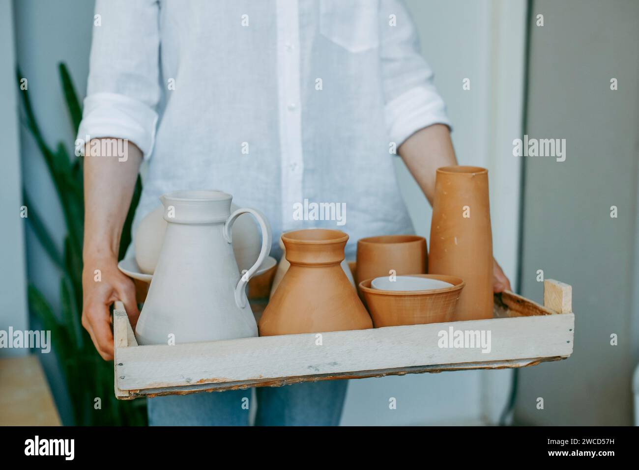Various clay jugs and dishes, ready for firing and decoration Stock Photo