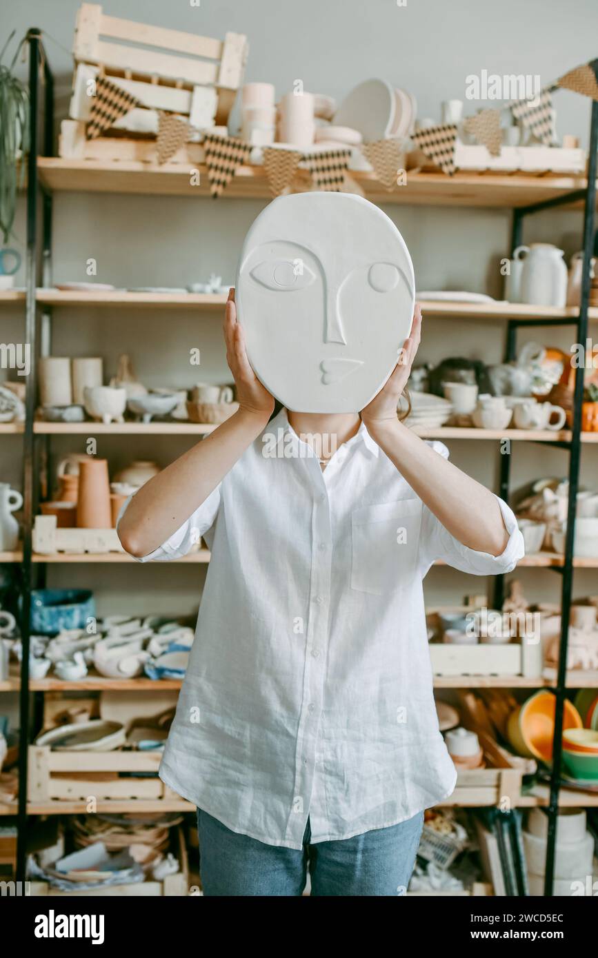 A clay face in a woman's hands, instead of a head Stock Photo