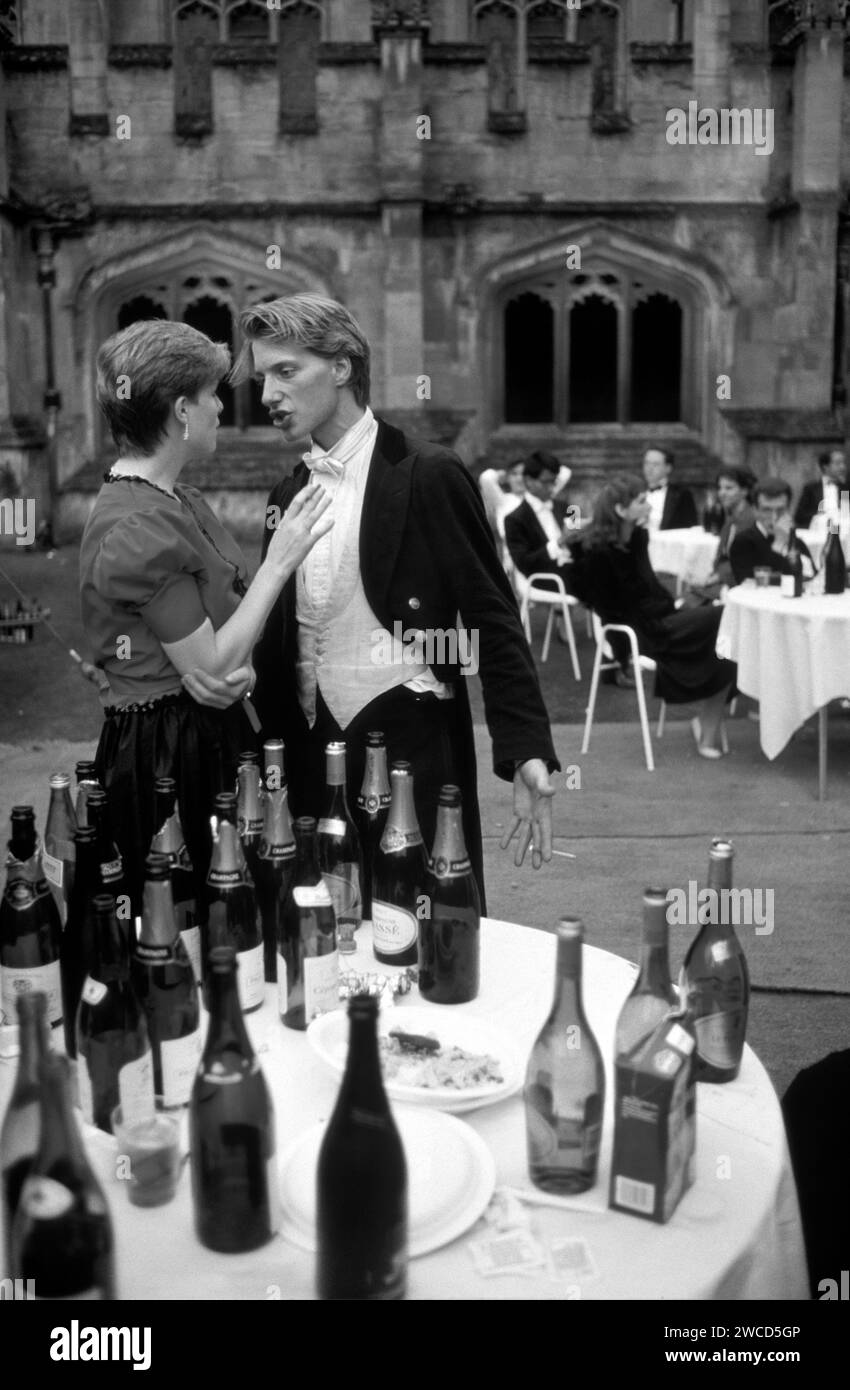 Argument. The morning after the night before, dawn has broken and his temper has too. Dishevel in his drunkenness, Champagne fuelled and perhaps a little tired; a reveller wearing White tie and a brown velvet family hand-me-down dress suit lets his partner know exactly what he thinks. They’re in the Quad after the Magdalen College Commem Ball. Oxford, England June 1985. 1980s UK HOMER SYKES Stock Photo