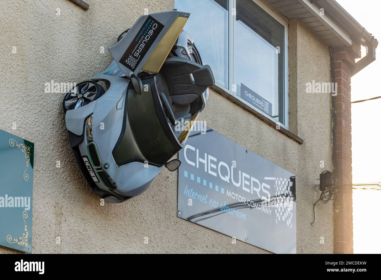 Quirky shop front with a car on the wall at Chequers Motor Company