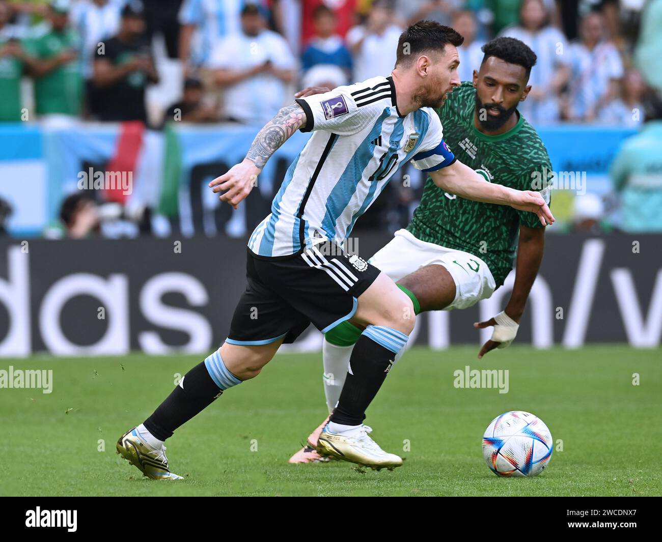 Lionel Messi looks ahead as he plans his next move against a Saudi Arabian defender during the 2022 FIFA World Cup in Qatar. Saudi Arabia wins 2-1. Stock Photo